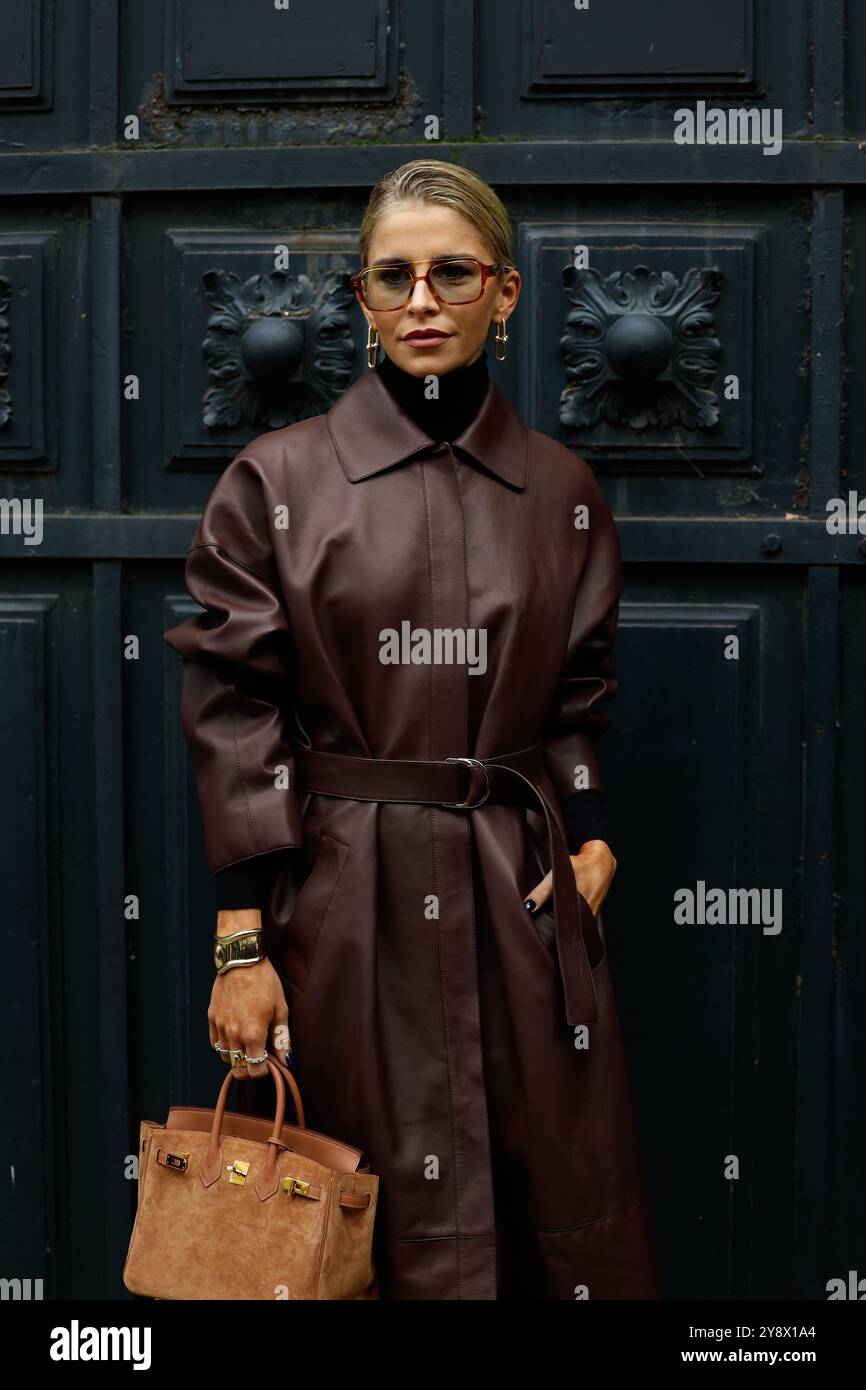 Caro Daur portant une veste-manteau longue en cuir rouge/marron/bordeaux, un pull col tortue noir, un sac birkin marron daim chez Hermès Paris Fashion week SS25 Banque D'Images