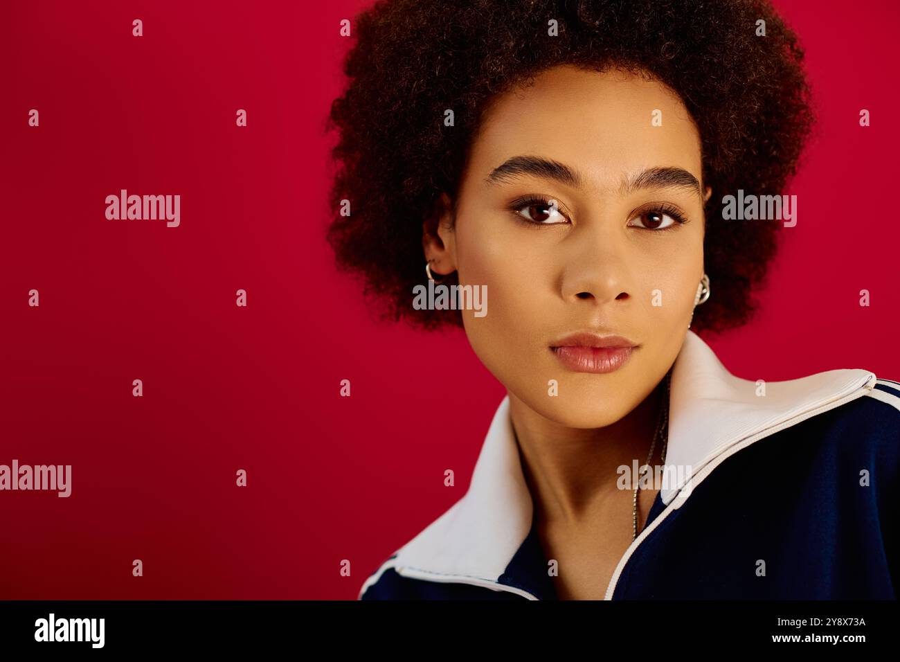 Une jeune femme transmet des émotions profondes sur un fond audacieux et coloré. Banque D'Images