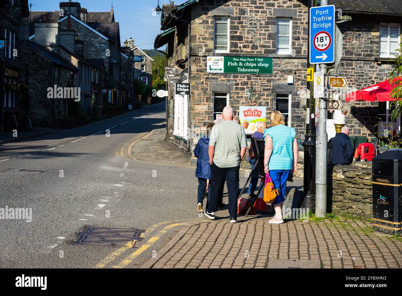 Touristes marchant à Betws y Coed, Nord du pays de Galles, Royaume-Uni. Banque D'Images