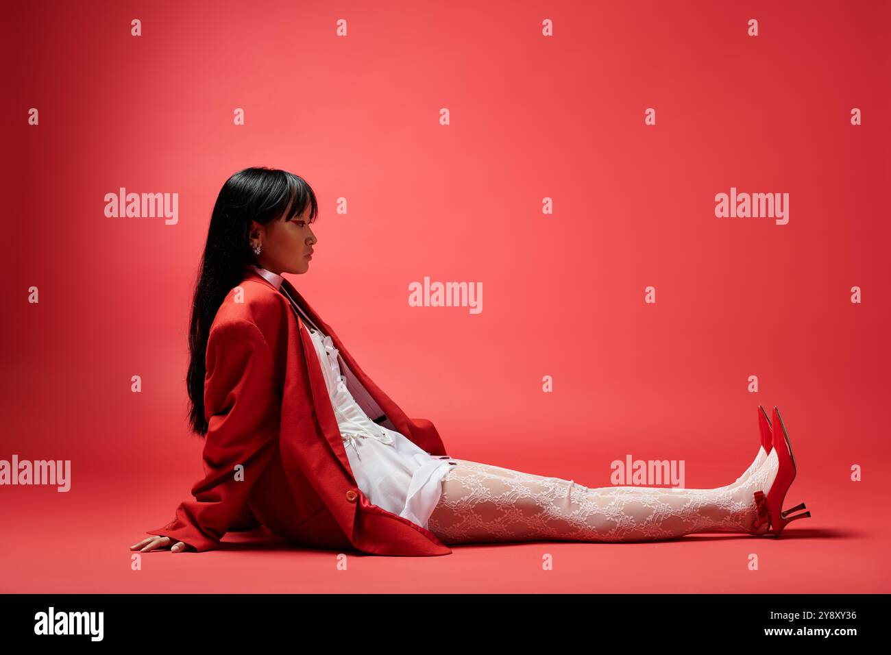 Avec une élégance serrée, une femme dans une tenue rouge montre son sens de la mode unique au milieu de couleurs vives. Banque D'Images
