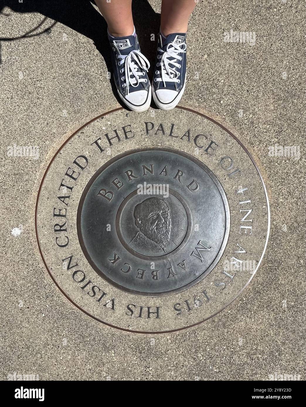 Pieds en chaussures Converse près de la plaque à Bernard Maybeck au Palais des Beaux-Arts construit à l'origine en 1915 et reconstruit entre 1964 et 1967. Banque D'Images