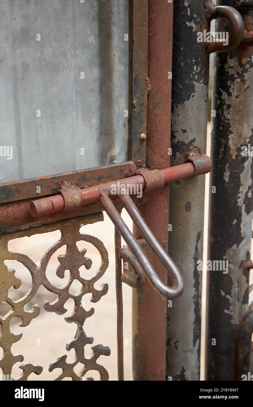 vieille charnière de boulon rouillé et serrure sur la porte extérieure en métal, matériel de verrouillage coulissant corrodé dans l'espace de mise au point douce et de copie Banque D'Images