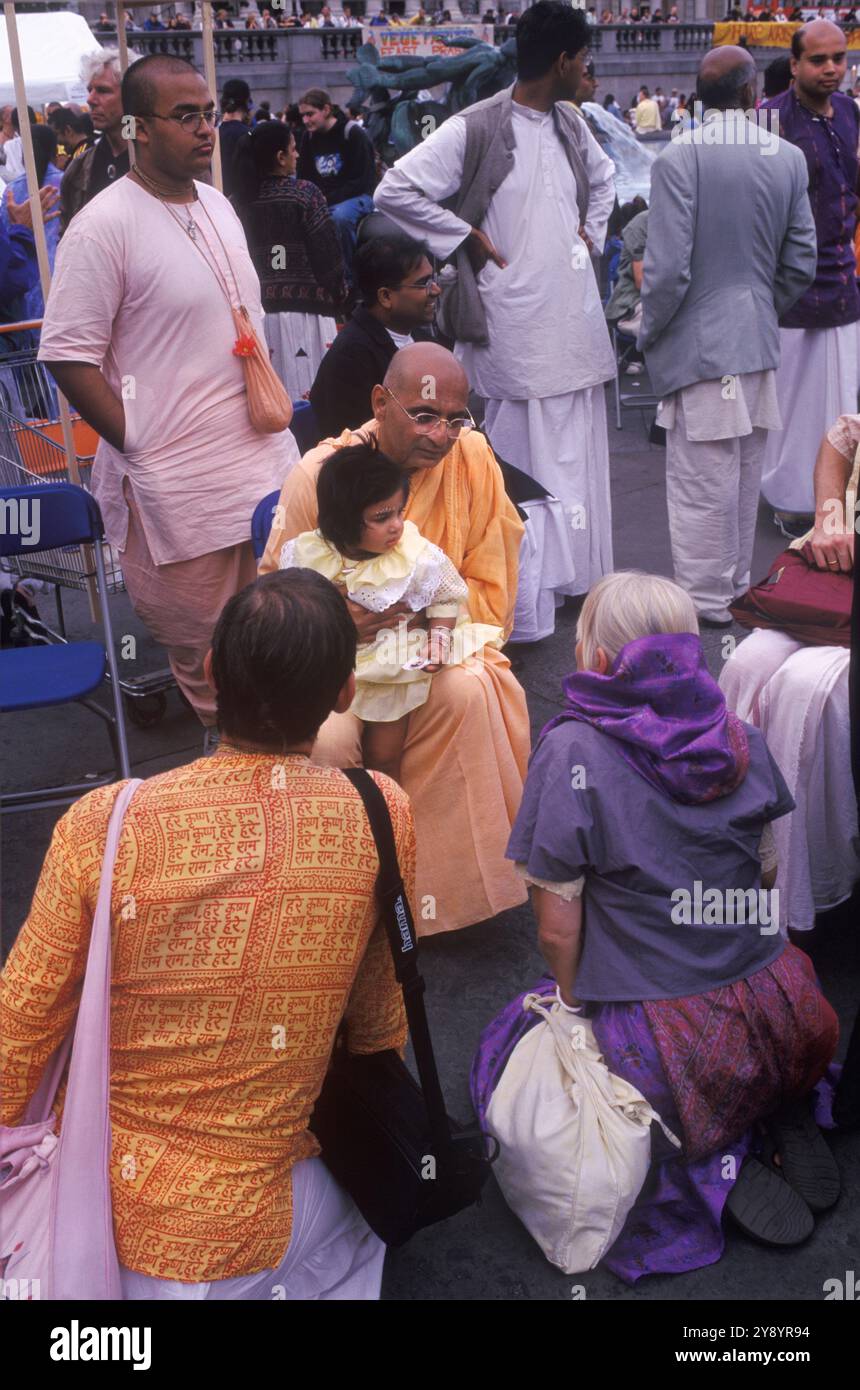 Moine hindou avec un enfant assis sur son genou, et ses parents agenouillés à partir du moine. Le festival de Rathayatra, Trafalgar Square Londres Angleterre des années 2005 2000 Royaume-Uni HOMER SYKES Banque D'Images