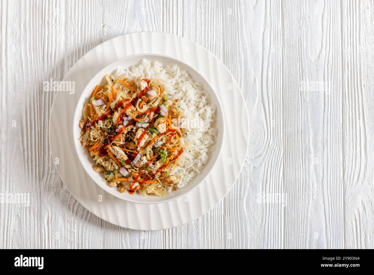 rouleau d'oeuf de tofu, chou sautés, tofu émietté assaisonné jeté dans une sauce sucrée et salée servie sur du riz dans un bol sur une table en bois blanc, plat, Banque D'Images
