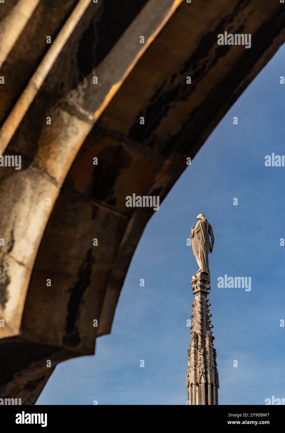 Photo d'une flèche et d'une statue du toit du Duomo di Milano ou de la cathédrale de Milan. Banque D'Images