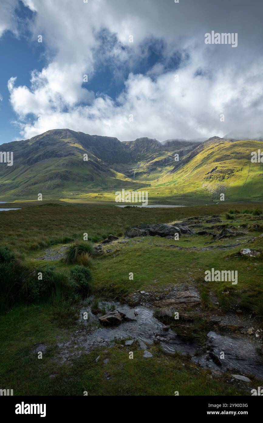 Jeu de lumière et d'ombre à travers l'herbe verte luxuriante des pentes de montagne à Doo Lough Valley, Glencullin Mountain, comté de Mayo, Irlande Banque D'Images