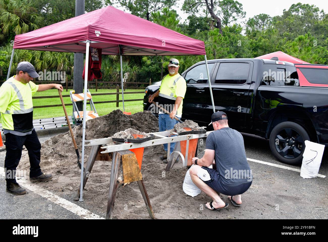 West Melbourne, Floride, Comté de Brevard, Floride États-Unis. 7 octobre 2024. De nombreuses stations-service du sud de Brevard étaient en panne d'essence avant l'arrivée de l'ouragan Milton. Les voitures ont été reculées dans de longues files d'attente pour l'arrivée des camions de livraison. Le West Melbourne Community Park dispose de sacs de sable pré-remplis et de plusieurs stations pour le faire soi-même. Les voitures ont été reculées autour du parc et jusqu'à Minton Road. Soyez prêt à attendre. La police est sur place pour diriger la circulation. Crédit : Julian Leek/Alamy Live News Banque D'Images
