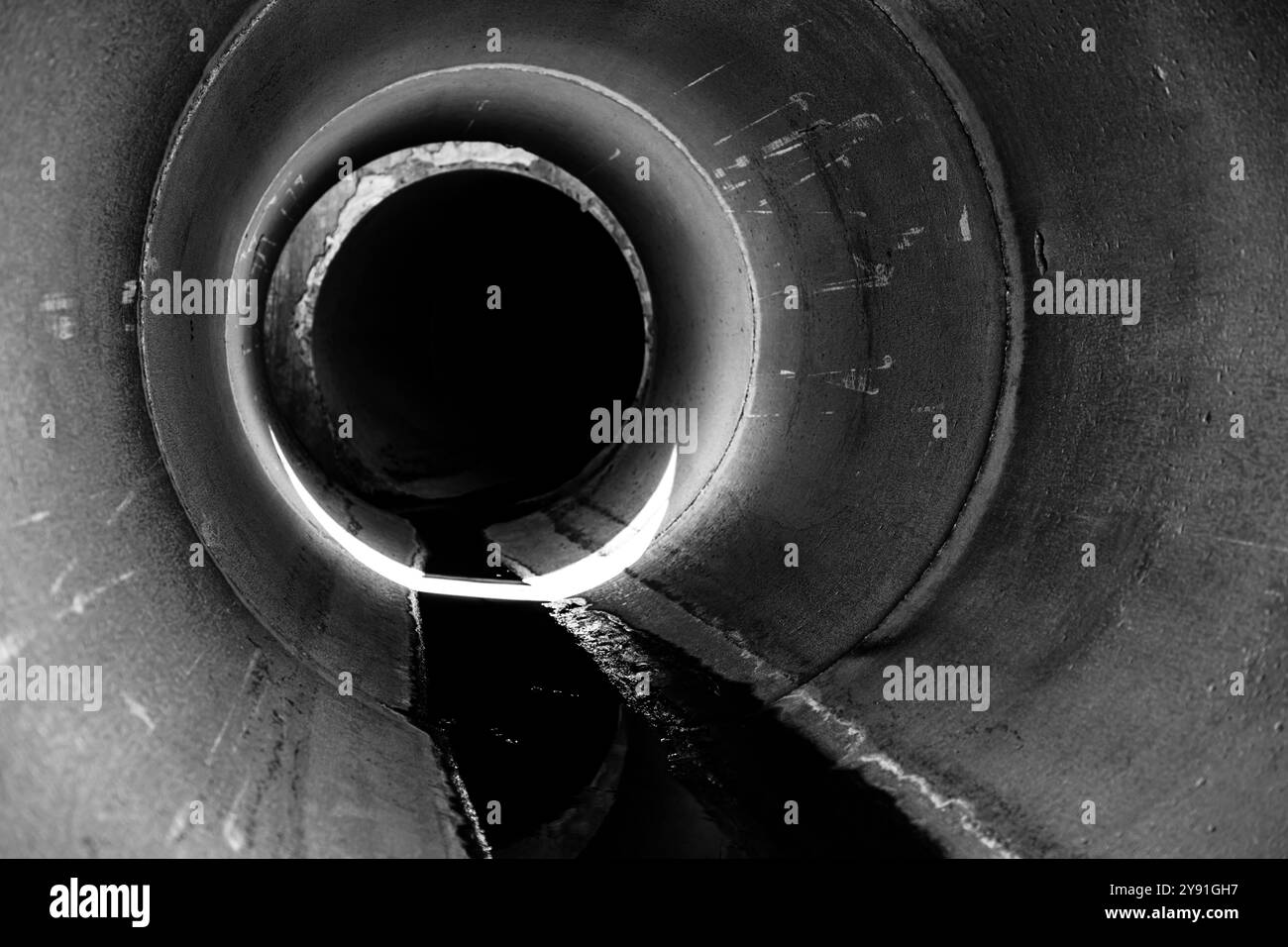 À l'intérieur d'un ponceau circulaire de drainage en béton avec un filet d'eau Banque D'Images