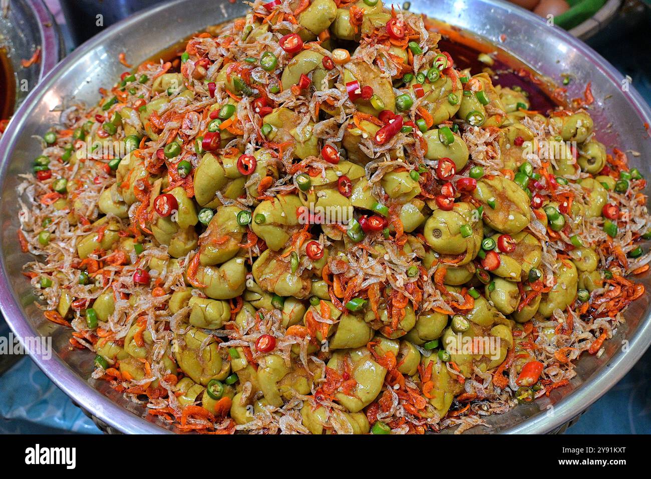 Plateau de cornichons marial vert aigre, Bouea macrophylla, en vente sur un stand de cuisine de rue thaïlandais, servi avec des crevettes séchées et du piment Banque D'Images