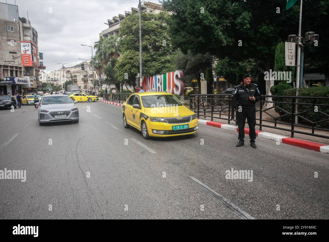 Naplouse, Palestine. 07 octobre 2024. Un policier palestinien ferme une rue aux véhicules palestiniens pendant un quart d'heure dans la ville de Naplouse en Cisjordanie pour protester contre la guerre entre Israël et le mouvement de résistance islamique Hamas dans la bande de Gaza. Les citoyens palestiniens célèbrent l'anniversaire du 7 octobre 2023. Crédit : SOPA images Limited/Alamy Live News Banque D'Images