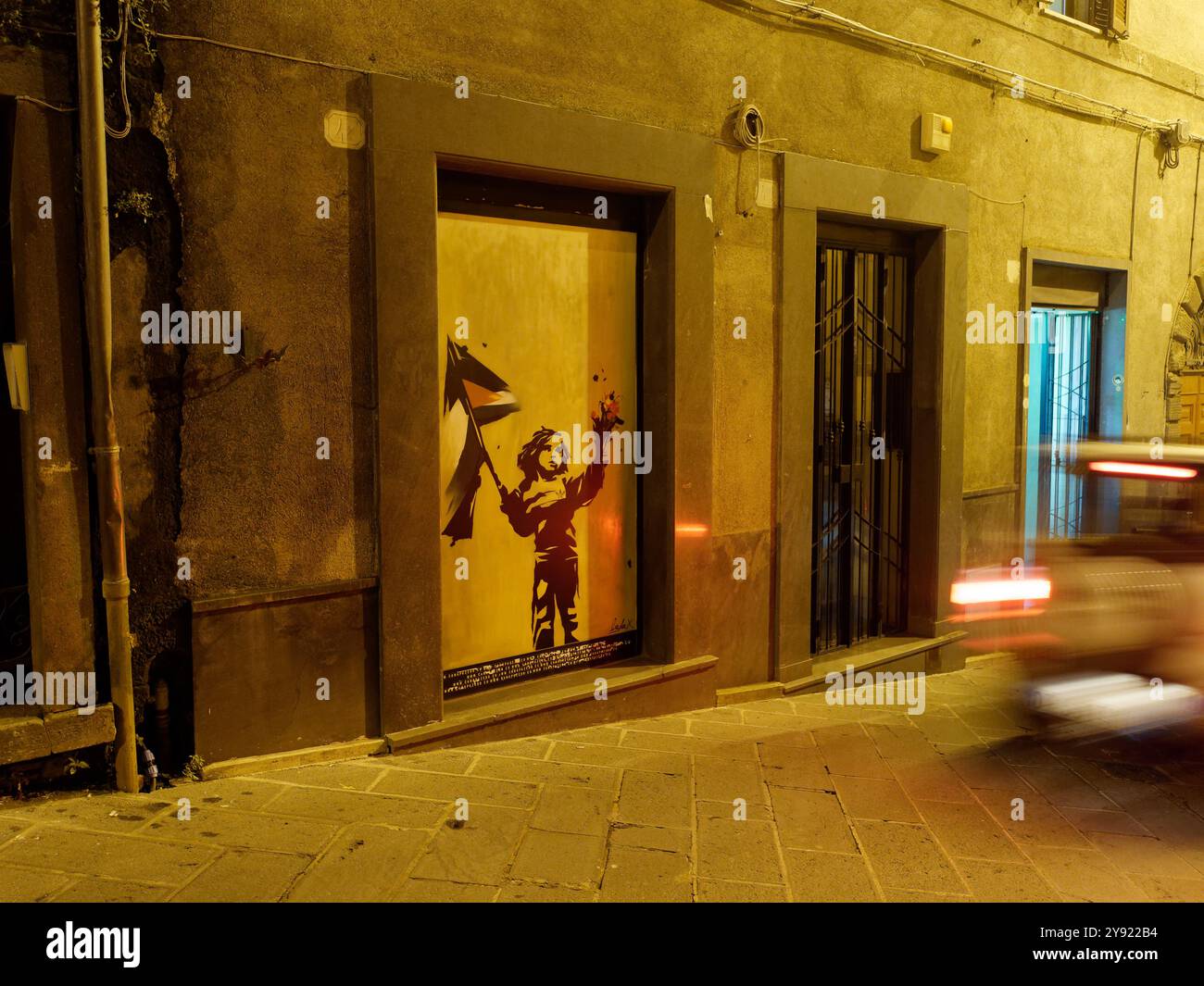 Street Art sur la rue Corso Cavour la nuit comme la voiture siffle dans la ville de Montefiascone, région du Latium, Italie. 7 octobre 2024 Banque D'Images