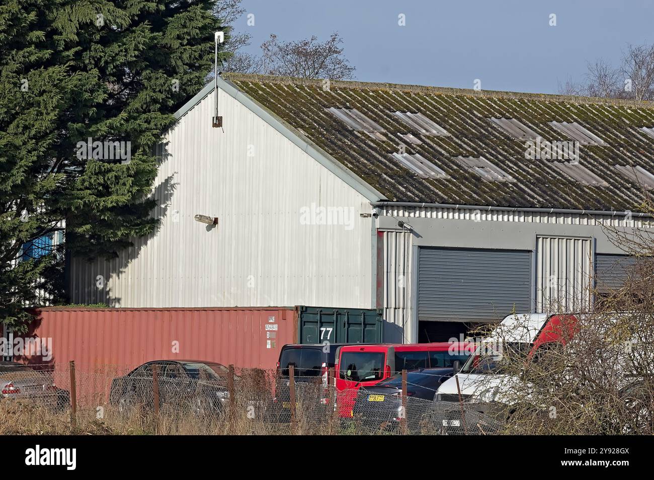 Gros plan d'un bâtiment d'entrepôt avec des véhicules garés sur Redstone Industrial Estate Banque D'Images
