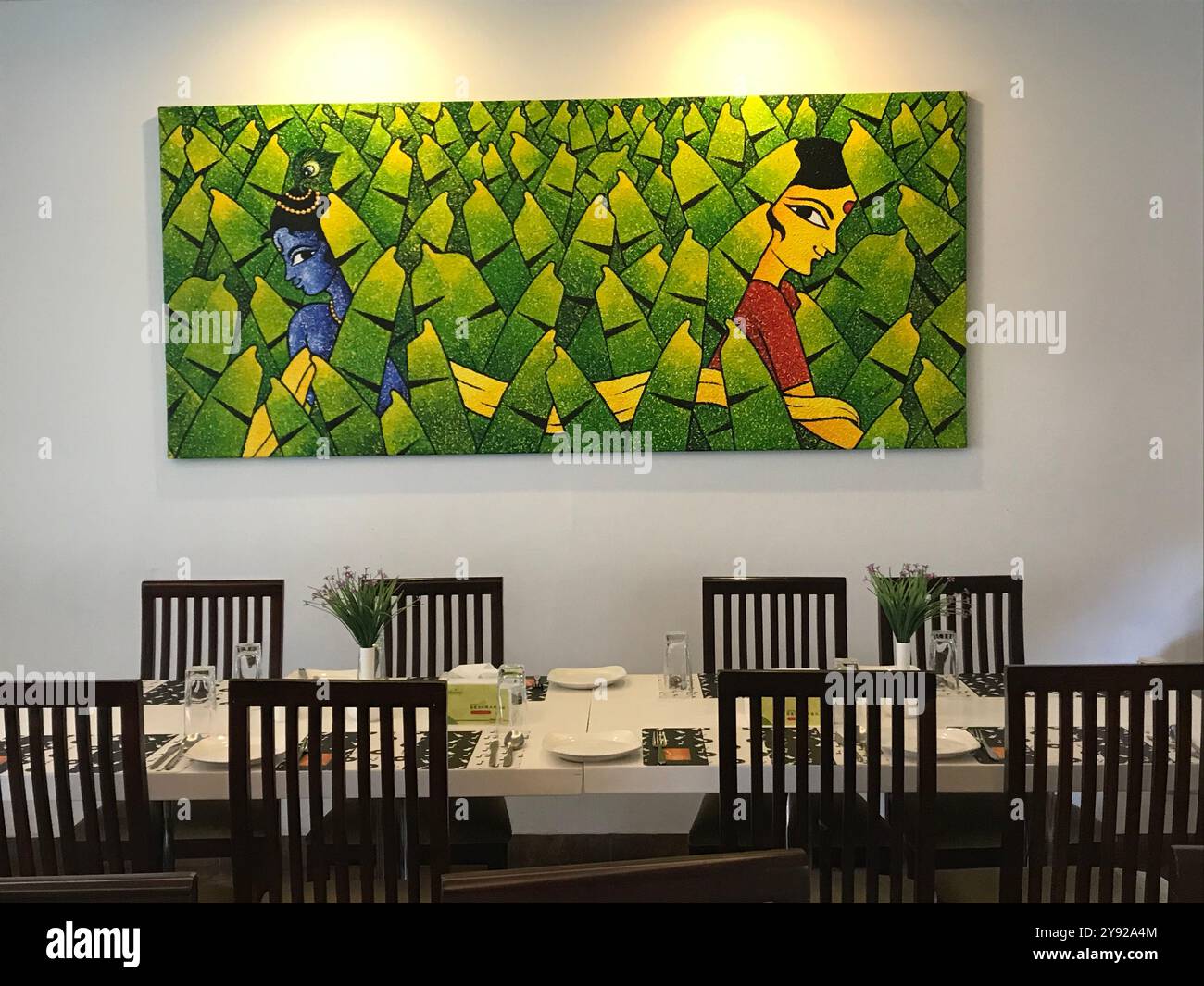 Intérieur moderne du restaurant avec des œuvres d'art vibrantes et la configuration de la salle à manger, mettant en valeur une expérience culinaire chaleureuse et artistique Banque D'Images