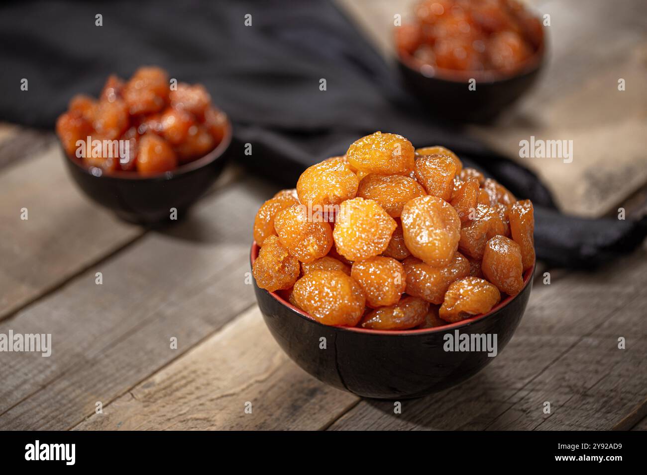 Abricots séchés glacés dans un bol noir, mettant en valeur leur couleur et leur texture orangée dorée, parfaits pour des idées de collations ou de desserts sains Banque D'Images