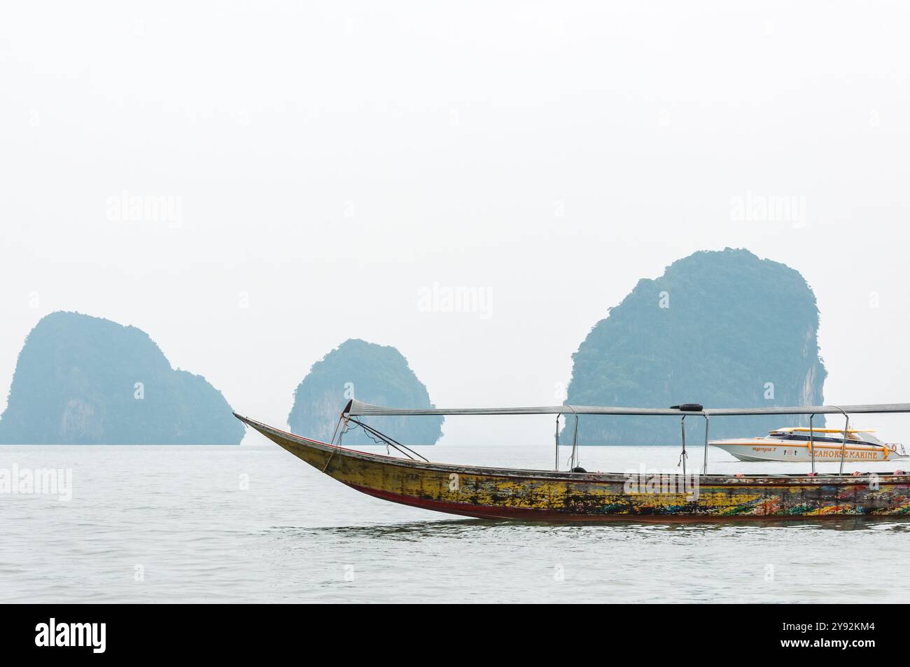 Phang Nga, Thaïlande - 26 octobre 2016 : bateau traditionnel à longue queue sur des eaux sereines avec karsts calcaires. Banque D'Images