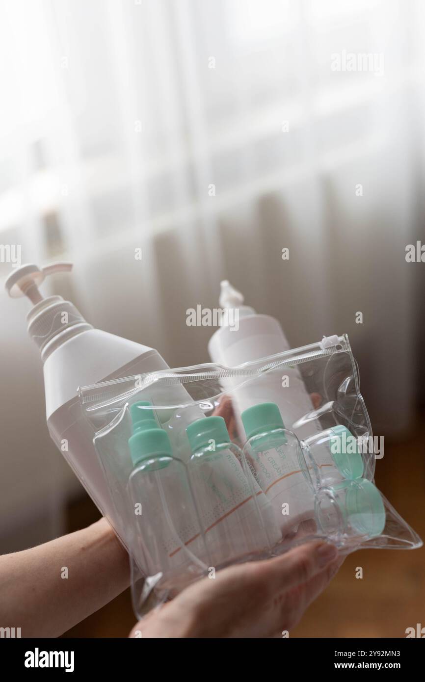 Cosmétologue montre au client un produit cosmétique et une bouteille de voyage. Photo de haute qualité Banque D'Images