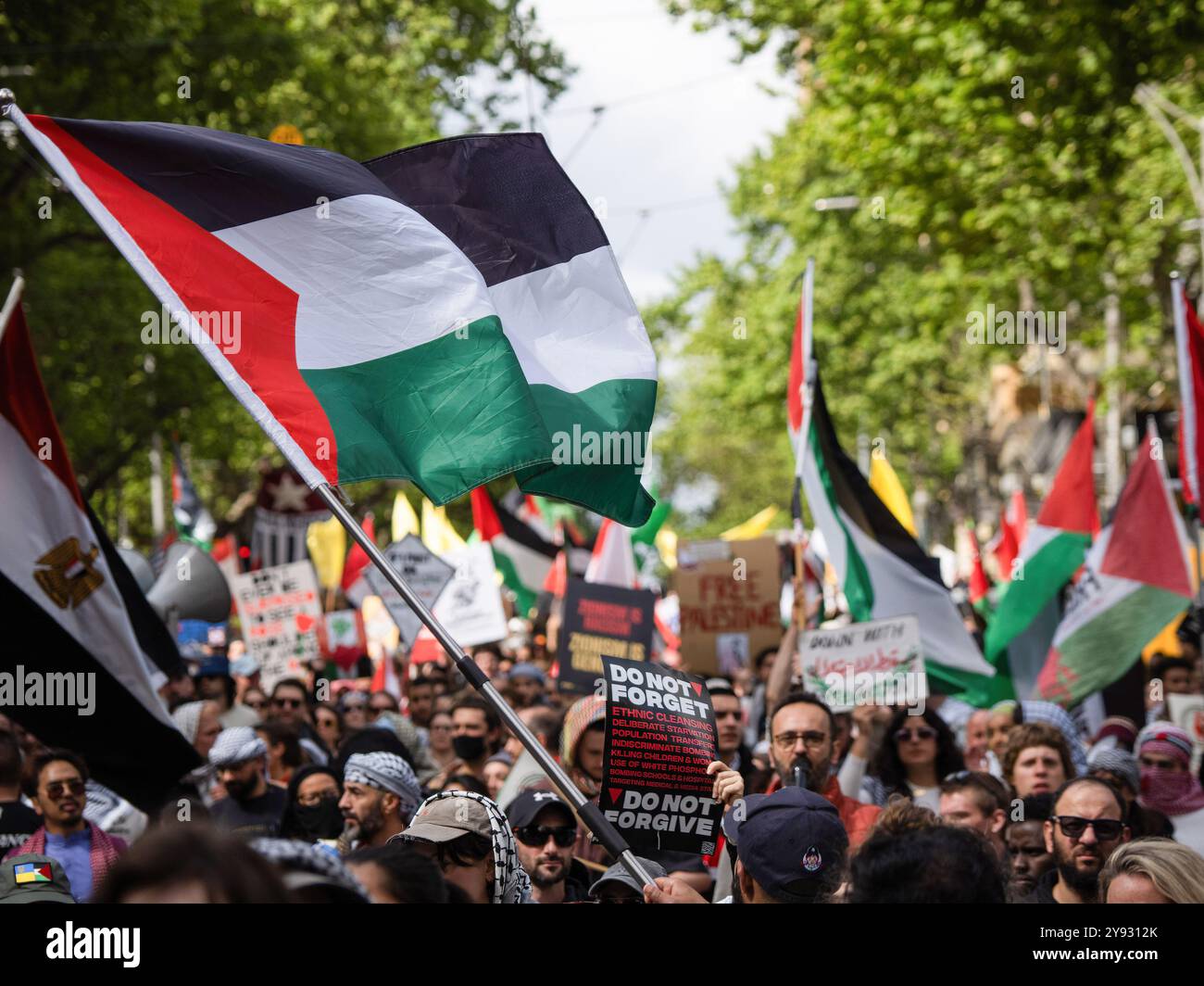 Melbourne, Australie. 06 octobre 2024. Un drapeau palestinien est agité au-dessus du rassemblement. Des milliers de personnes se sont rassemblées dans le centre-ville de Melbourne pour commémorer une année depuis l'invasion israélienne de Gaza. De l'autre côté de la rivière à Southbank, un groupe plus petit s'est réuni pour commémorer une année depuis l'attaque du 7 octobre 2023 contre Israël. (Photo Alex Zucco/SOPA images/SIPA USA) crédit : SIPA USA/Alamy Live News Banque D'Images