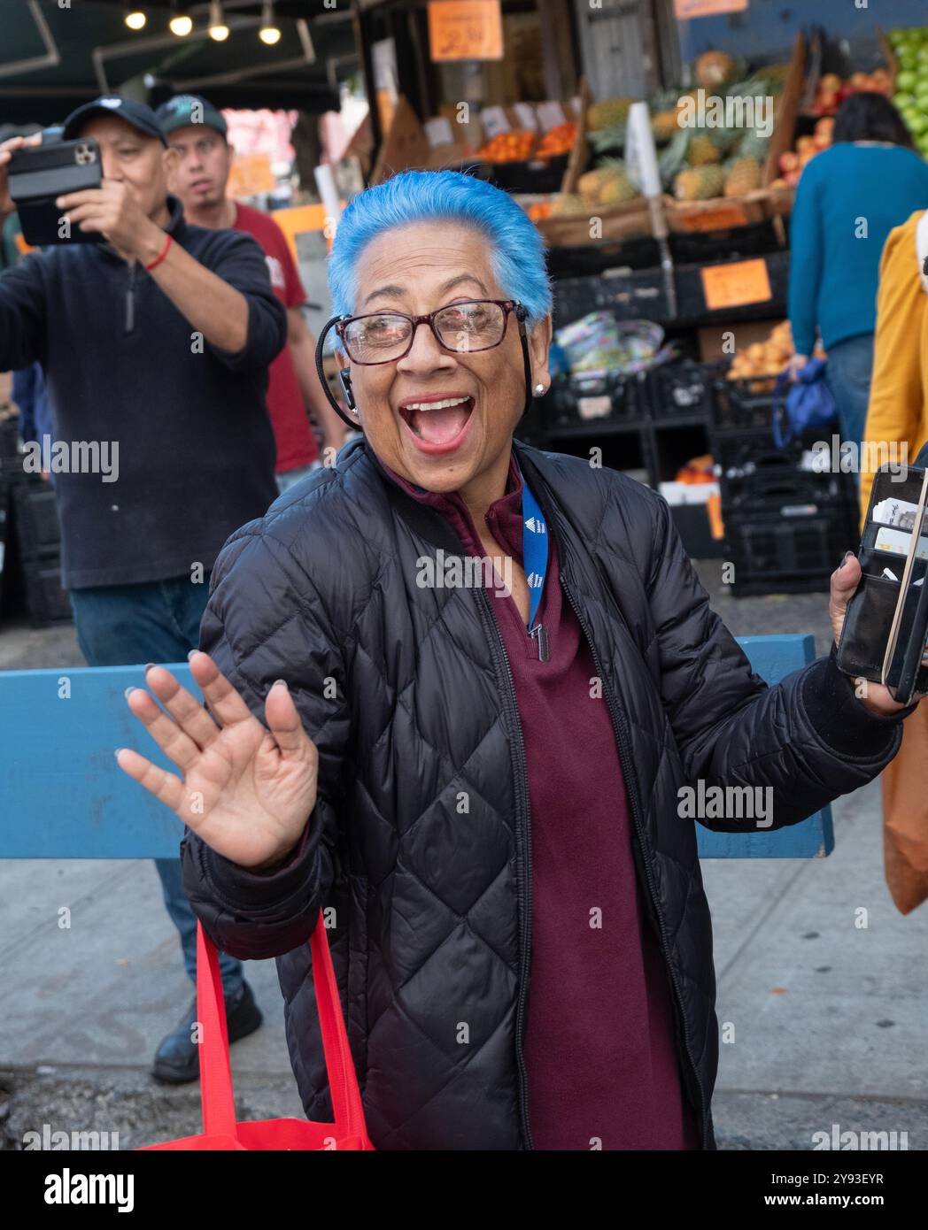 Une femme plus âgée, peut-être dans la soixantaine, avec des cheveux cyan bleu vif. Au défilé Dominicain Day sur la 37e Avenue à Jackson Heights, Queens. Banque D'Images