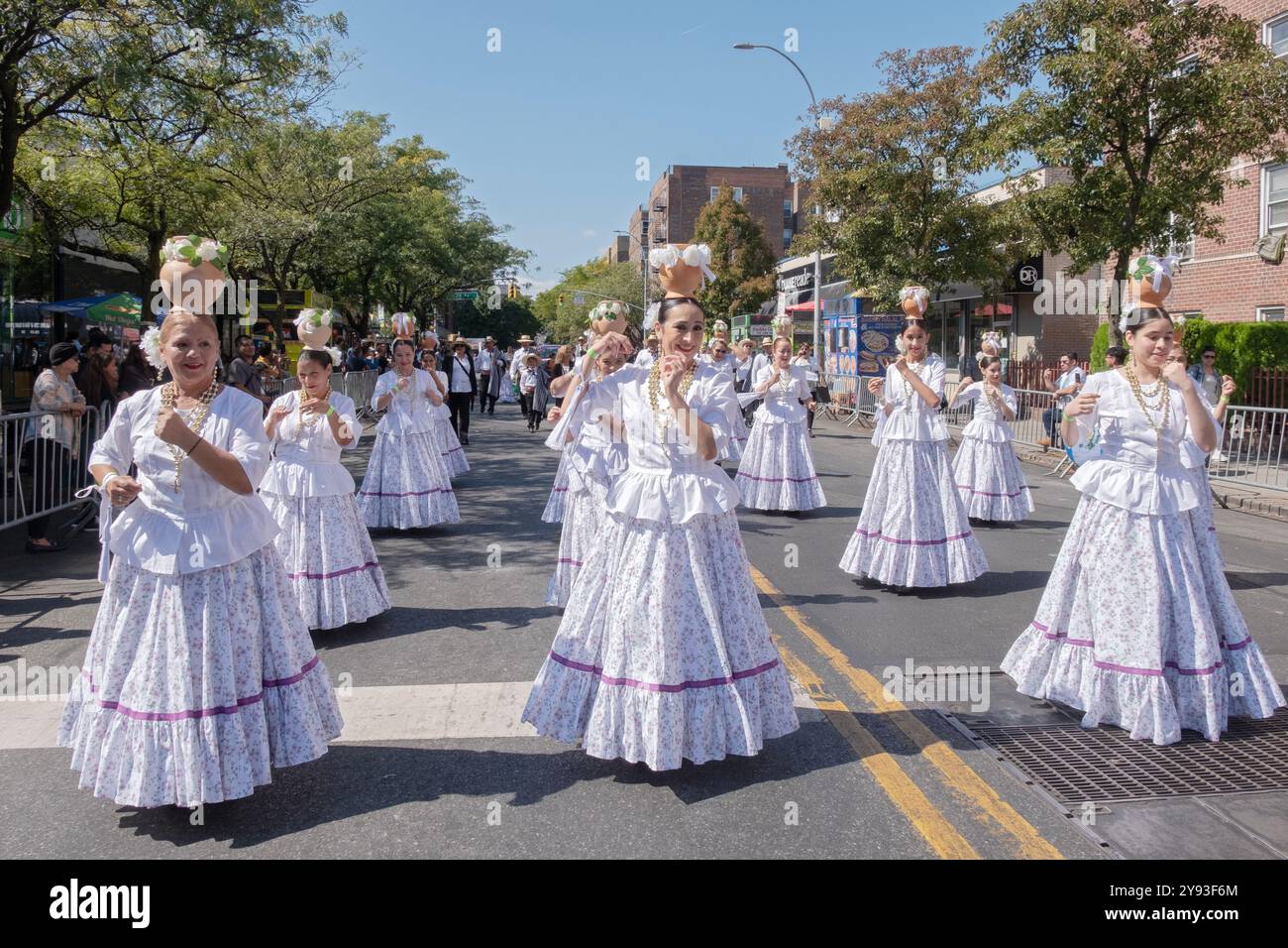 Un groupe de femmes paraguayennes d'âge varié danse et marche en costumes blancs. Au défilé du jour hispanique du Queens 2024 à Jackson Heights. Banque D'Images