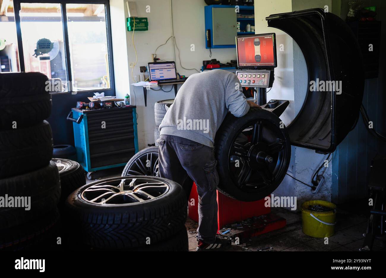 07.10.2024, Geretsberg, AUT, Unterwegs in Innviertel, Symbolbild, Themenbild, Verschiedene Themenbilder, Reifen Wechsel, im Bild Ein Mechaniker montiert Winterreifen an einem Auto in einer KFZ-Werkstatt. AM 1. Novembre débutant à Österreich für Pkw und LKW bis 3,5 Tonnen die situative Winterausrüstungspflicht. // Un mécanicien automobile monte des pneus hiver sur une voiture dans un garage. Le 1er novembre, l'obligation d'équipement hivernal de situation commence en Autriche pour les voitures particulières et les camions jusqu'à 3,5 tonnes, Autriche, Reifen, Montieren, montage, Wuchten, *** 07 10 2024, Geretsberg, AUT, Unterwegs in Innviertel, S Banque D'Images