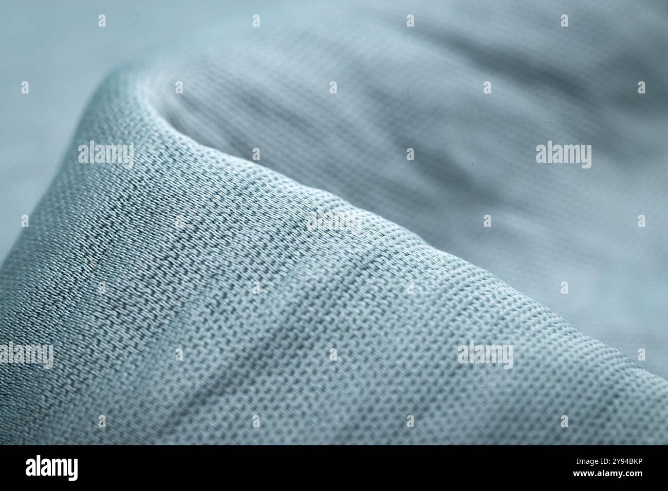 Gros plan en tissu bleu texturé montrant de fins détails tissés, idéal pour l'industrie textile, la mode et les arrière-plans de décoration intérieure Banque D'Images