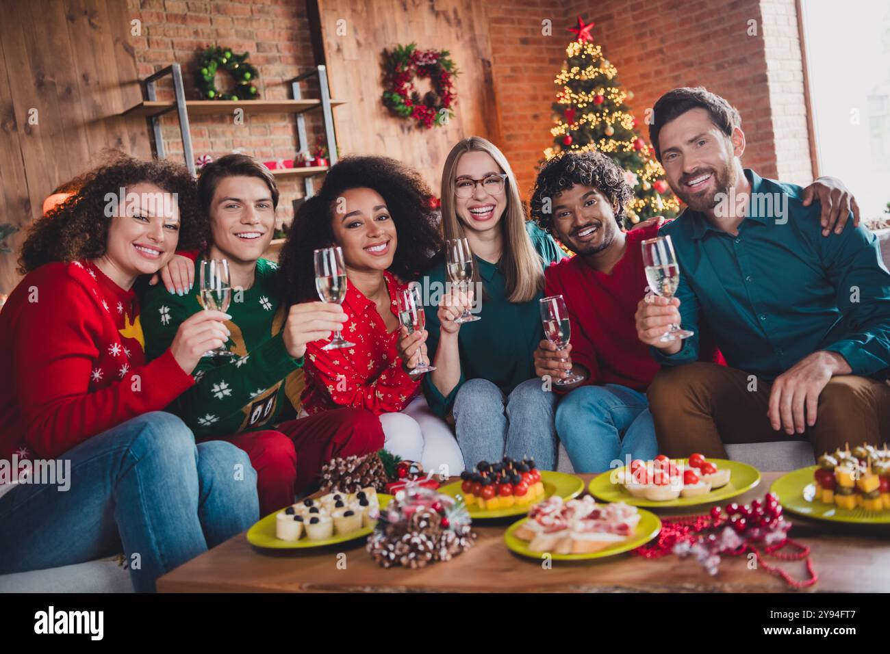 Photo de jeunes gentils boire champagne tenir verre profiter de décoration de noël confortable maison intérieure à l'intérieur de la partie Banque D'Images