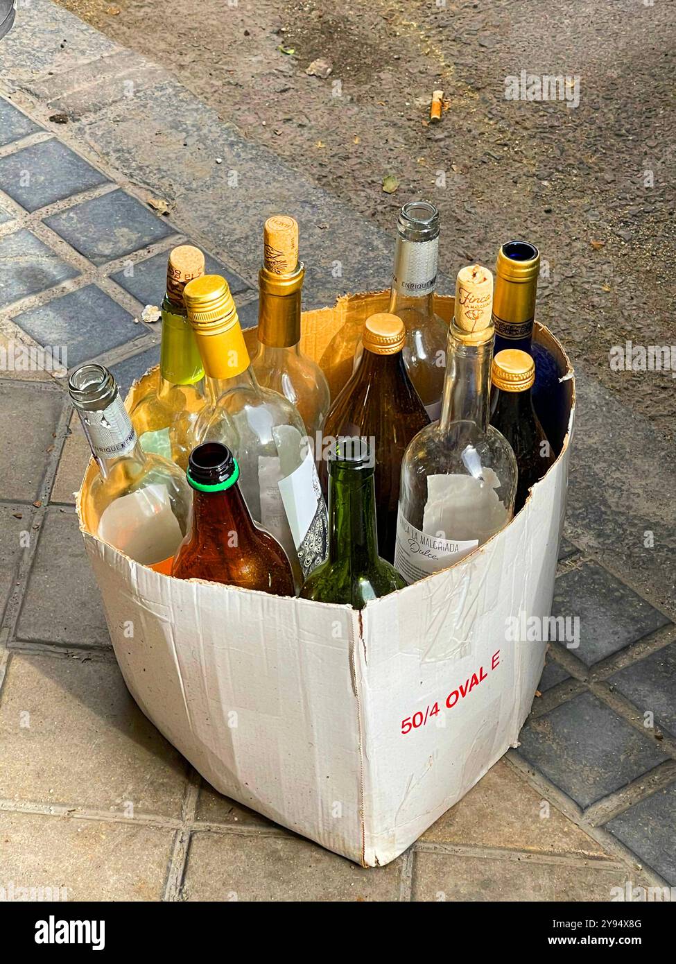 Bouteilles vides dans une boîte, abandonnées dans la rue. - Image de stock capturée avec un smartphone