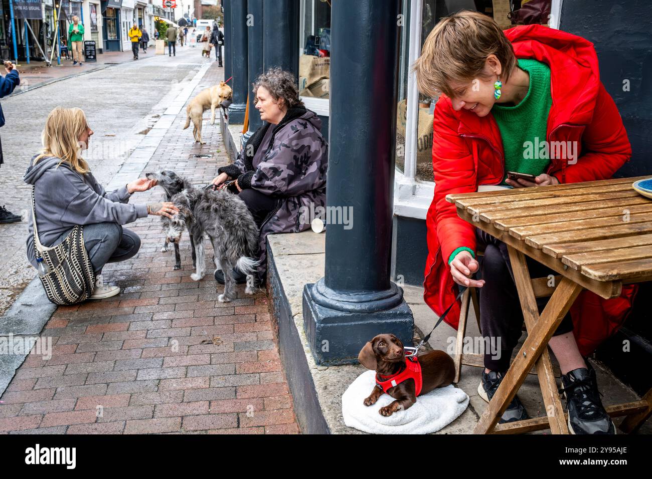 Les habitants de la région avec leurs animaux assis à l'extérieur D'Un café dans la High Street, Lewes, East Sussex, Royaume-Uni. Banque D'Images