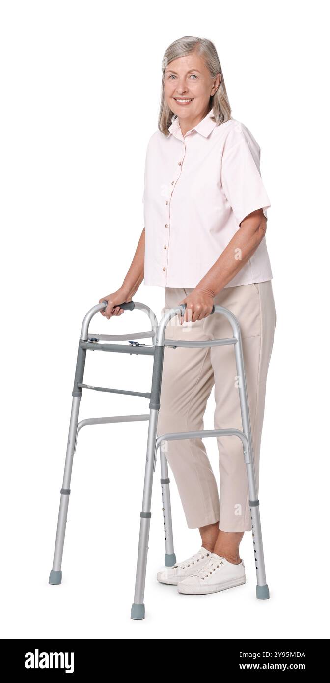 Femme senior utilisant le cadre de marche sur fond blanc Banque D'Images
