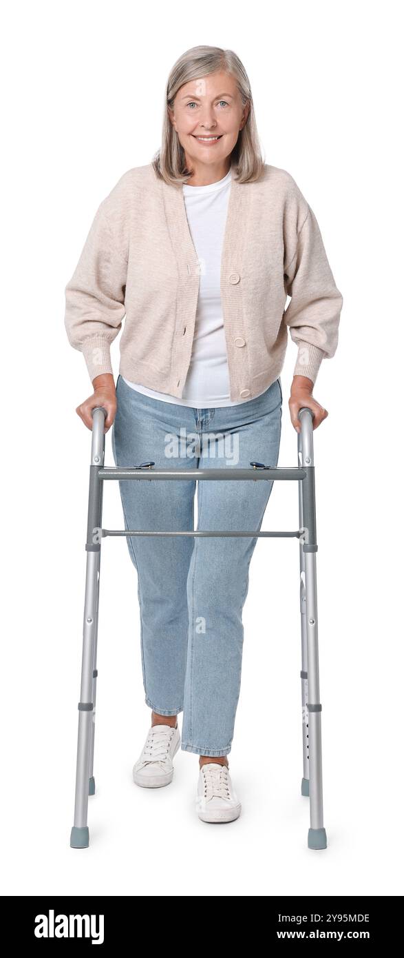 Femme senior utilisant le cadre de marche sur fond blanc Banque D'Images