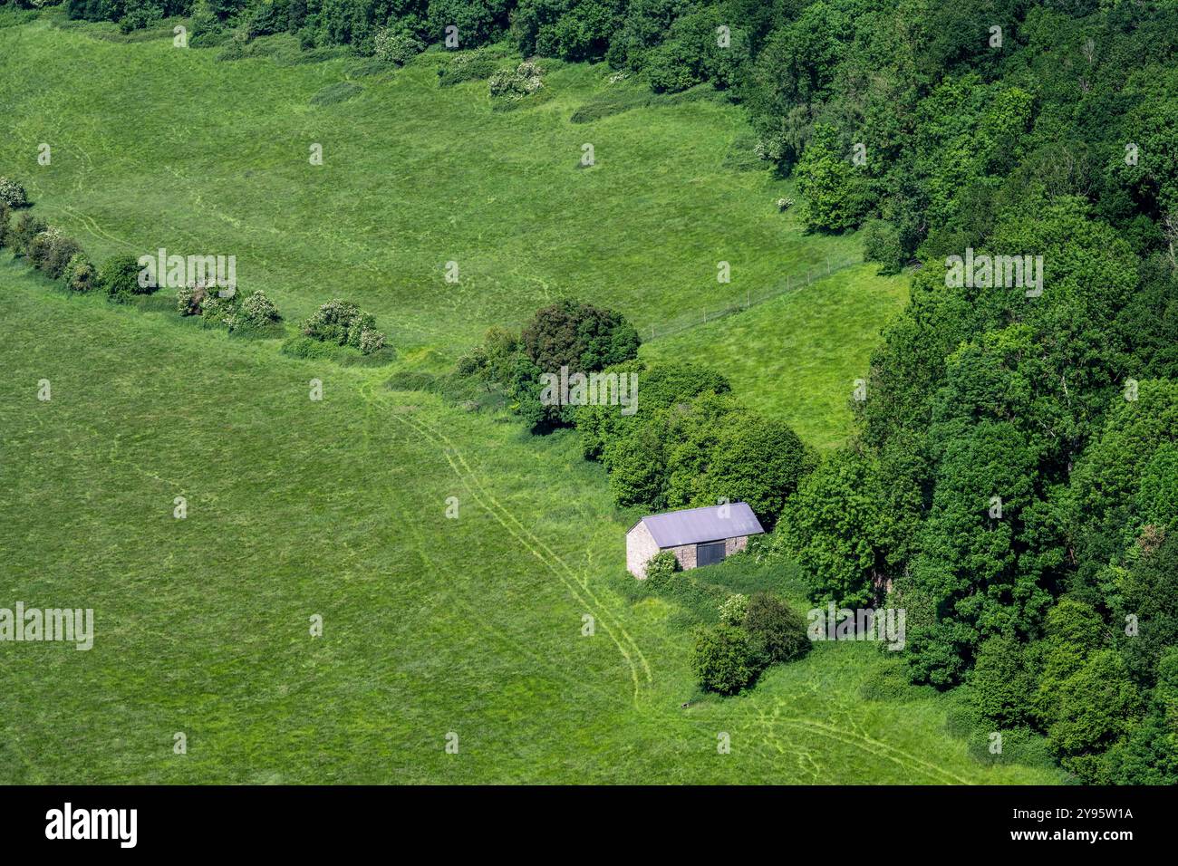 Une grange en pierre traditionnelle se dresse parmi les champs agricoles et les bois à Goodrich dans le Herefordshire, vu de Symonds Yat. Banque D'Images