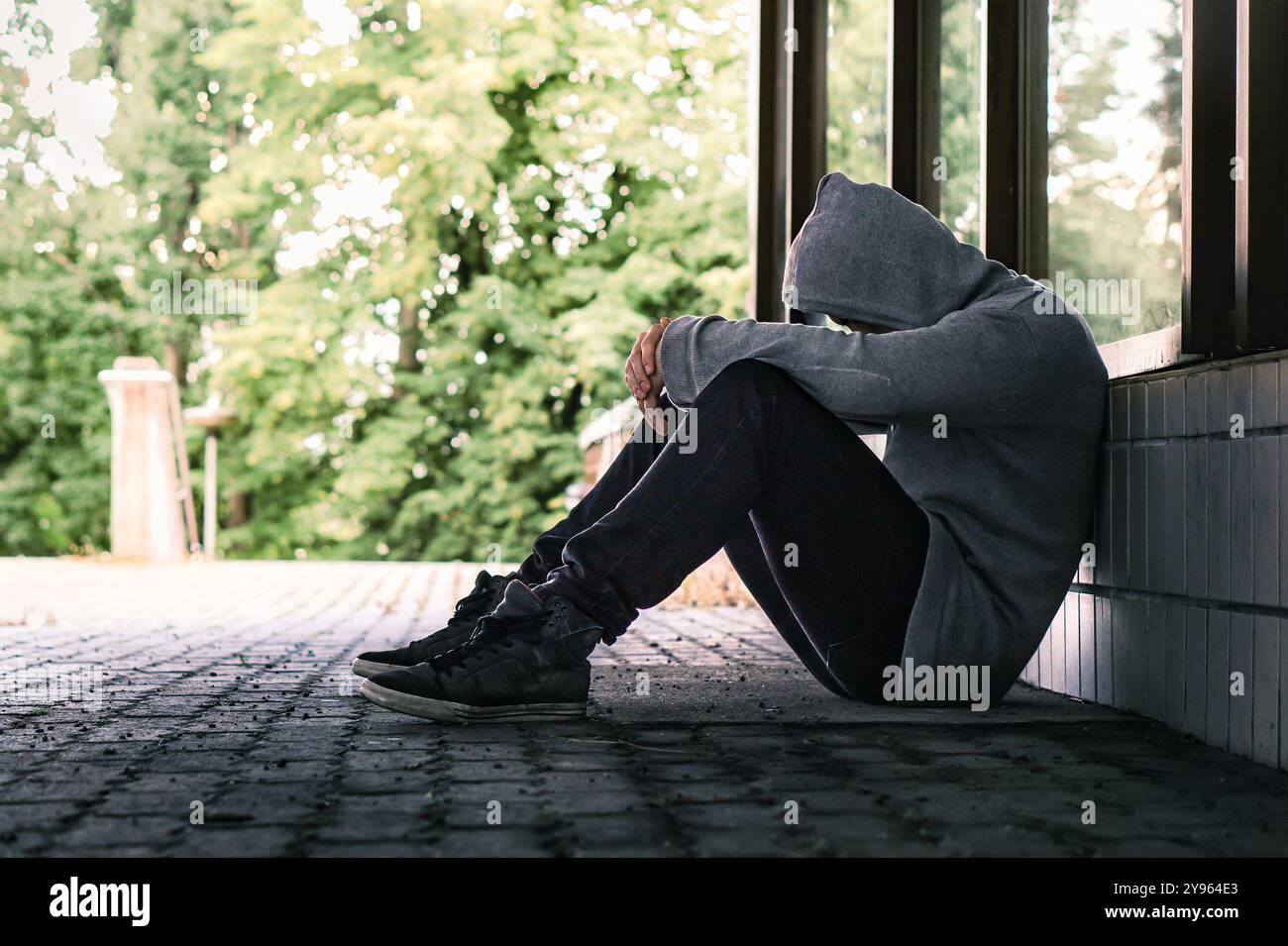 Traumatisme ou culpabilité d'un triste déprimé. Les sans-abri exclus avec toxicomanie dans la rue de la ville. Solitude, désespoir ou discrimination. Honte de la victime. Banque D'Images