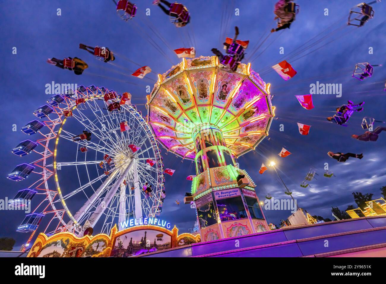 Carrousel à chaînes et grande roue dans la soirée. 177e Cannstatter Volksfest au Cannstatter Wasen. Bad Cannstatt, Stuttgart, Bade-Wuerttemberg, GE Banque D'Images