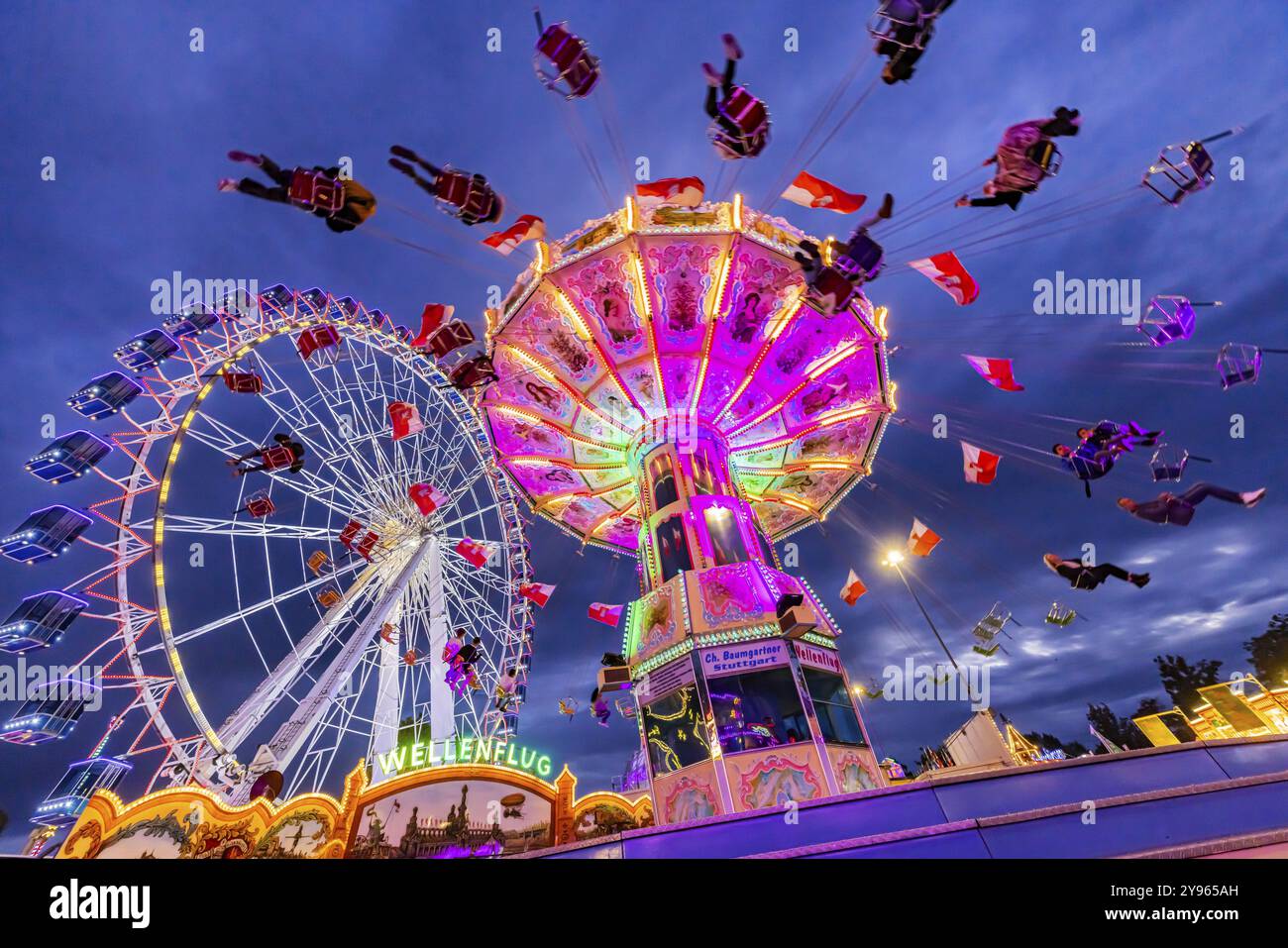 Carrousel à chaînes et grande roue dans la soirée. 177e Cannstatter Volksfest au Cannstatter Wasen. Bad Cannstatt, Stuttgart, Bade-Wuerttemberg, GE Banque D'Images