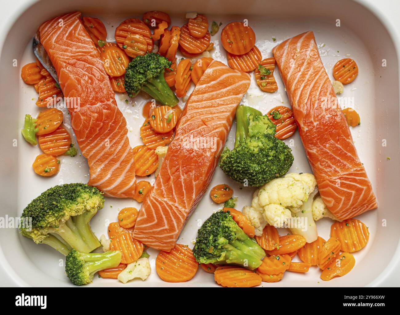 Vue de dessus de la casserole de plat de cuisson avec steaks de saumon crus de poisson non cuit, brocoli, chou-fleur, carotte. Préparer un concept de dîner sain à faible teneur en glucides, fo Banque D'Images