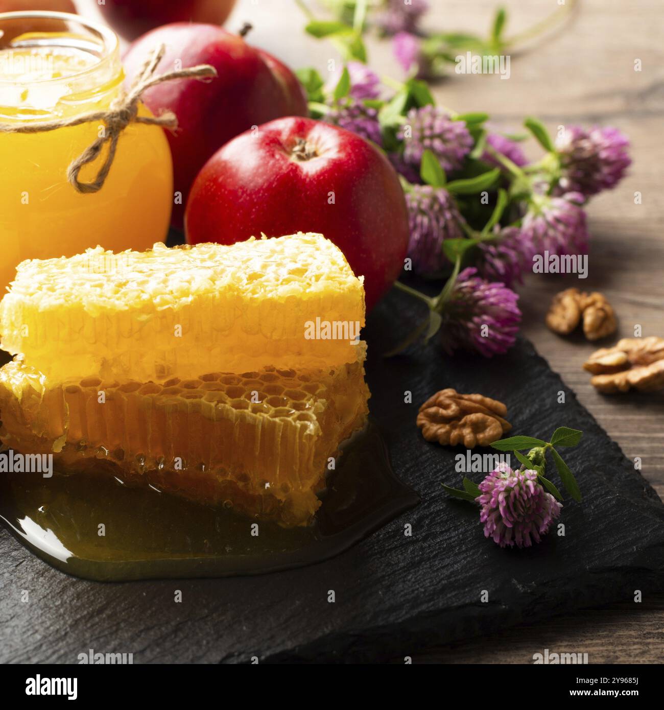 Pot Mason avec miel, nid d'abeille, pommes rouges et noix sur la table de cuisine, photographie alimentaire, photographie alimentaire Banque D'Images