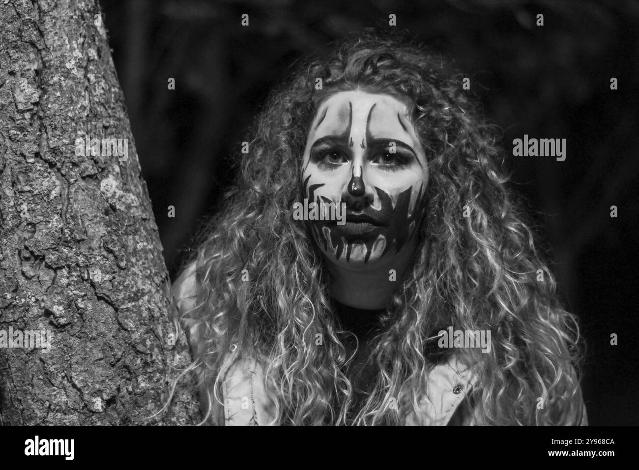 Jeune femme au maquillage d'halloween avec une bougie romaine la nuit. Gros plan d'une femme portant le maquillage d'halloween la nuit Banque D'Images