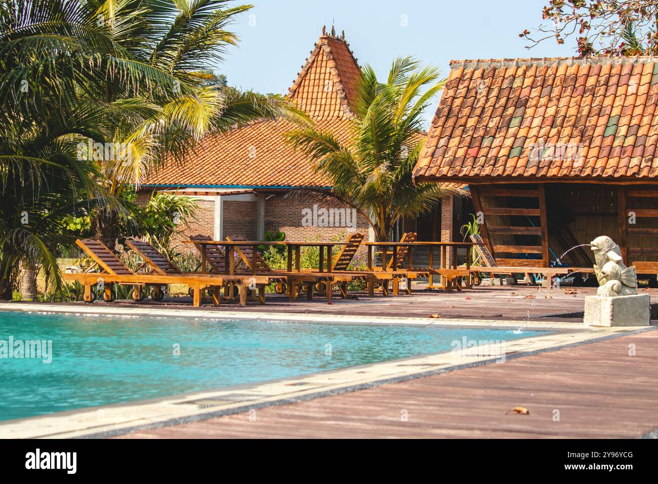 Journée ensoleillée au bord de la piscine dans une villa traditionnelle Retreat. Villa paisible nichée dans la beauté de la nature. Banque D'Images