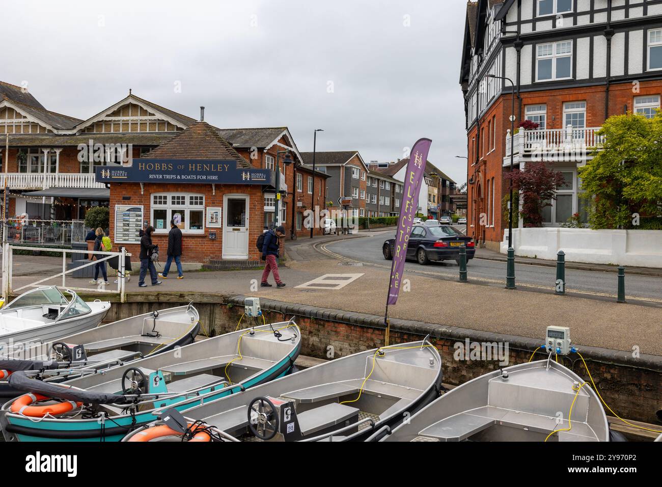 Piétons passant Hobbs of Henley avec des bateaux en premier plan Banque D'Images