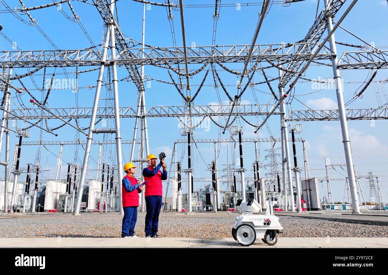 CHUZHOU, CHINE - 8 OCTOBRE 2024 - un robot intelligent et le personnel d'exploitation et de maintenance effectuent une inspection spéciale de l'équipement principal i. Banque D'Images