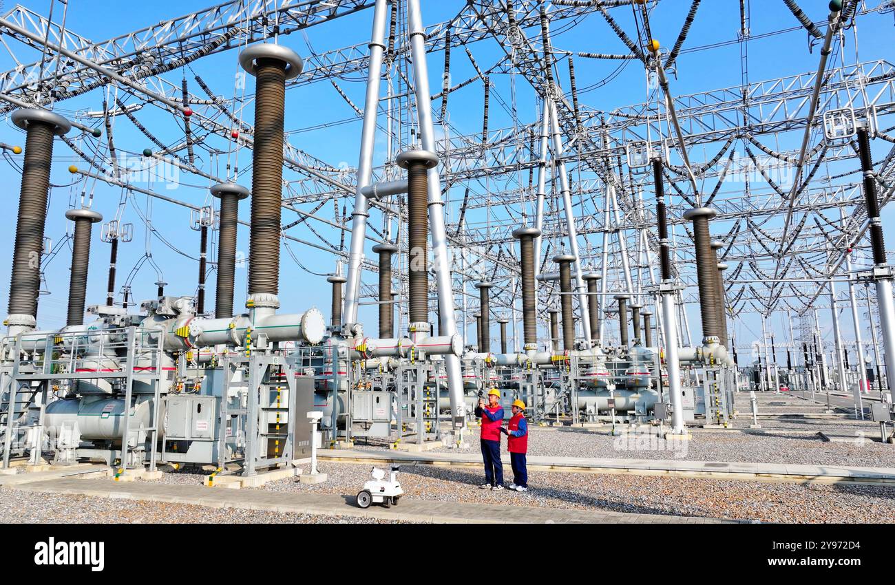 CHUZHOU, CHINE - 8 OCTOBRE 2024 - un robot intelligent et le personnel d'exploitation et de maintenance effectuent une inspection spéciale de l'équipement principal i. Banque D'Images