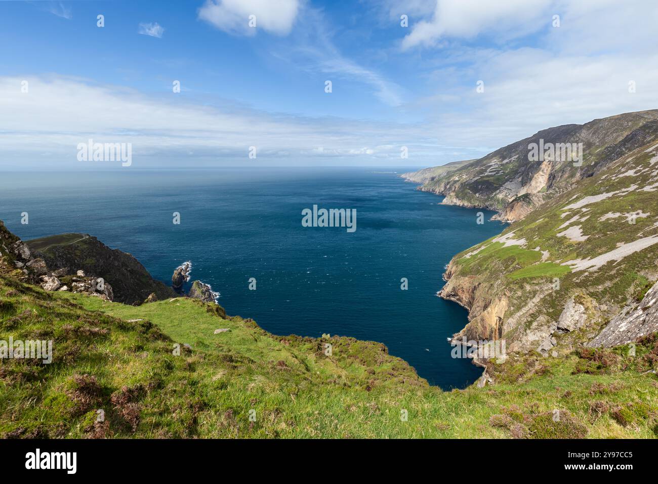 Les falaises spectaculaires de Slieve League en Irlande s'étendent dans l'océan Atlantique, avec des pentes herbeuses et des affleurements rocheux. La vue d'ensemble met en évidence t Banque D'Images