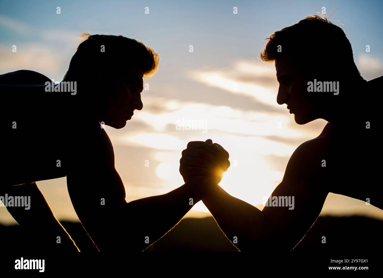 Silhouette de mains qui rivalisent en force, bras de lutte. Hommes mesurant les forces, les bras. Deux hommes luttent au bras. Rivalité, vs, défi, lutte à la main Banque D'Images