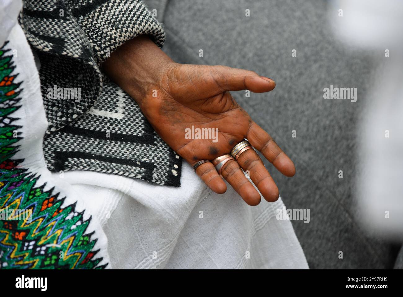 Gros plan sur les mains ouvertes et la tenue traditionnelle d'une éthiopienne juive priant lors de la célébration annuelle du SIGD à Jérusalem, Israël. Banque D'Images