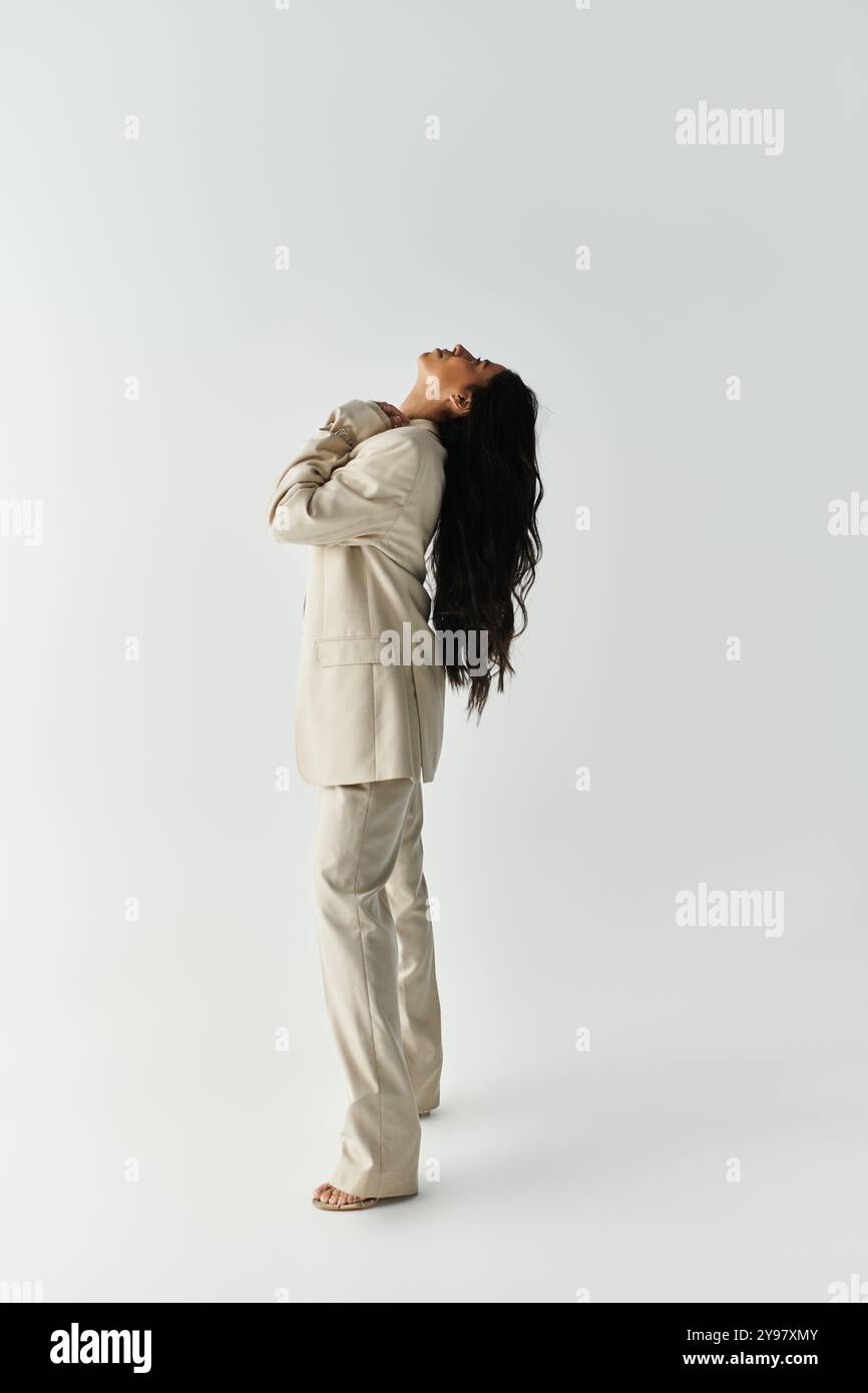 Une jeune femme élégamment habillée met en valeur l'élégance et la confiance dans une tenue moderne. Banque D'Images