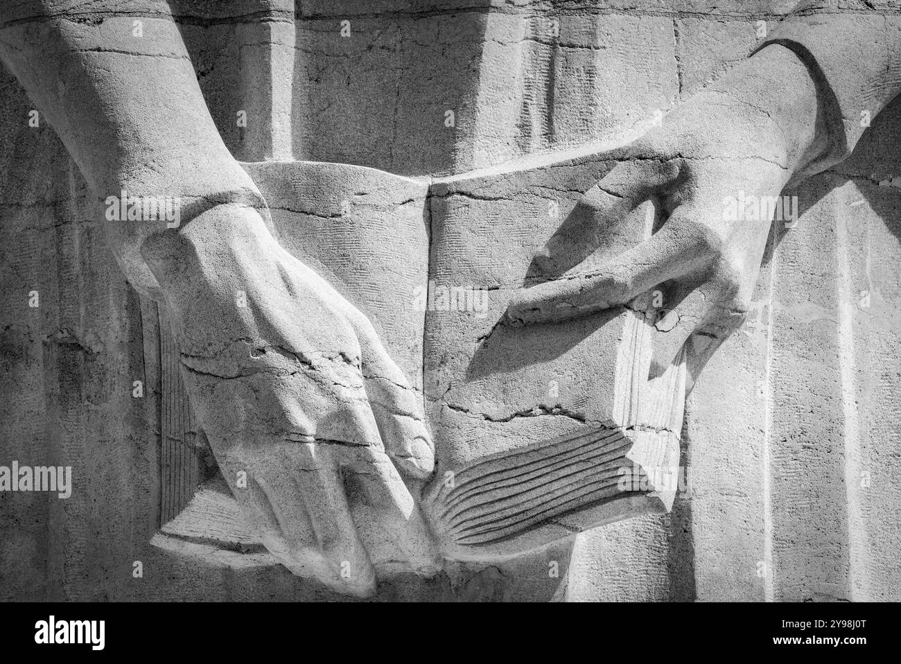 Statue de Jean Calvin, gros plan de ses mains tenant la Bible, sculptée dans la pierre, mur de la réforme dans le Parc des bastions Genève Suisse le 14 août Banque D'Images