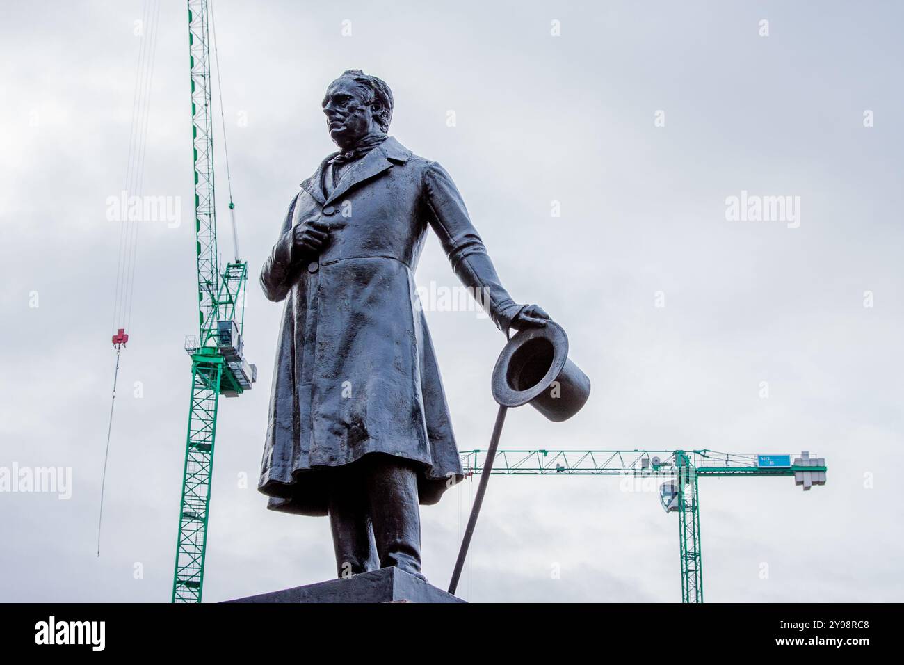 Statue de James Oswald MP, l'un des premiers députés du Parlement réformé de 1831, avec deux grues modernes en contraste derrière, George Square, Glasgow Banque D'Images