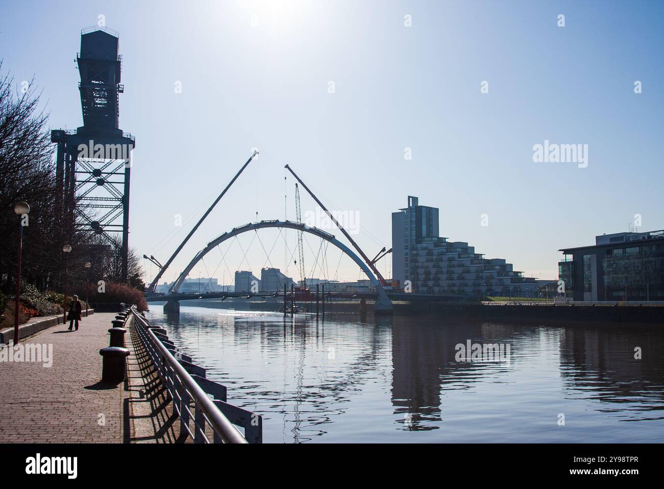 River Clyde avec la silhouette de deux grues et le pont Clyde Arc en cours de réparation et la grue Finnieston sur la gauche, Glasgow, Écosse Banque D'Images