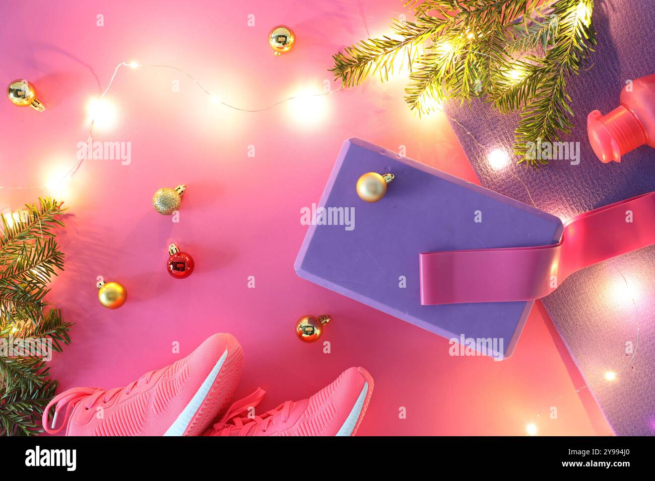 Composition plate de pose avec tapis de yoga et décor de Noël sur fond rose Banque D'Images