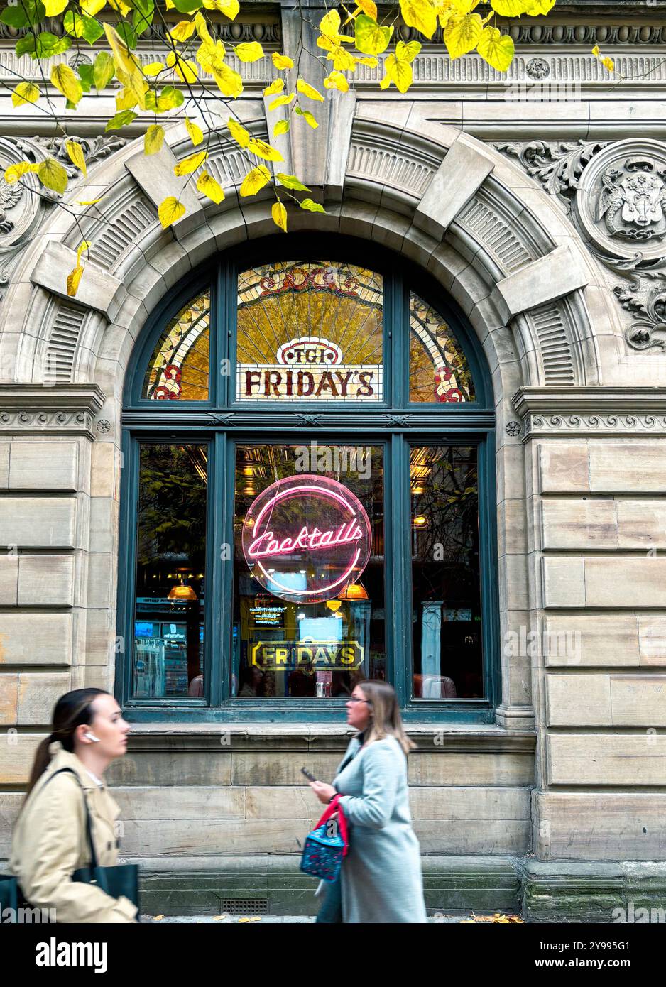 Les gens passant par la fenêtre de TGI Fridays Advertising cocktails, Buchanan Street, Glasgow, Écosse, Royaume-Uni Banque D'Images